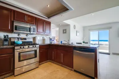 a kitchen with stainless steel appliances and a view of the ocean at Belmont Shores in San Diego