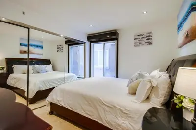 a bedroom with two beds and a mirror at Belmont Shores in San Diego