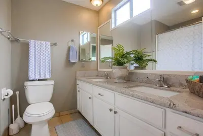 a bathroom with a toilet and a sink and a mirror at Beach Style 1 in San Diego