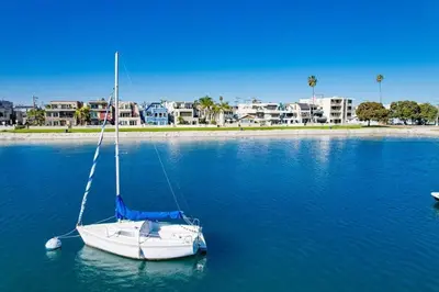 a white sailboat sitting in the middle of the water at Beach Style 1 in San Diego