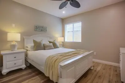 a bedroom with a white bed and a ceiling fan at Brighton Beach in San Diego