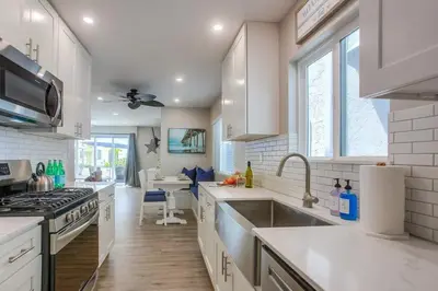 a white kitchen with a sink and a stove at Brighton Beach in San Diego