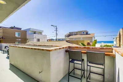 a patio with two chairs and a bar on a balcony at Beachy Keen 1 in San Diego