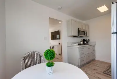 a white kitchen with a table and chairs and a counter at Boardwalk 2 in San Diego