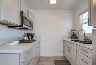 a kitchen with white cabinets and a stove top oven at Boardwalk 2 in San Diego