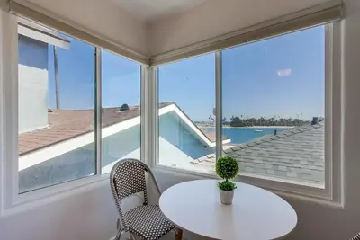 a white table and chairs in a room with windows at Boardwalk 2 in San Diego