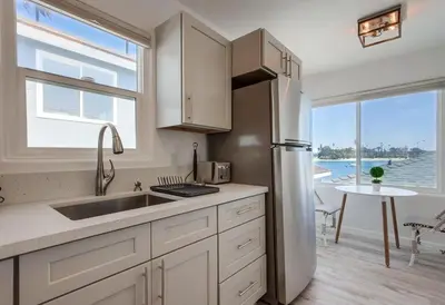 a kitchen with a stainless steel refrigerator and a table at Boardwalk 2 in San Diego