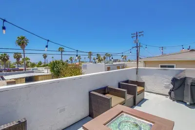 a balcony with wicker chairs and a table at Local Gem 4 in San Diego