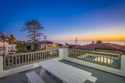 a wooden bench sitting on the balcony of a house at Ocean Oasis in Encinitas