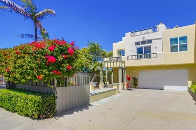 a house with a fence and flowers in front of it at Ocean Oasis in Encinitas