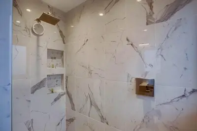 a bathroom with white marble walls and a shower at Boardwalk 6 in San Diego