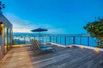 a deck with chairs and an umbrella on top of a building at Boardwalk 6 in San Diego