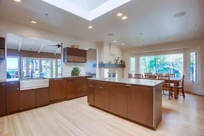 a large kitchen with wooden cabinets and a dining room at GrandView in Encinitas