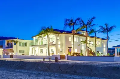 a large white house with palm trees in front of it at Point Break 1 in San Diego