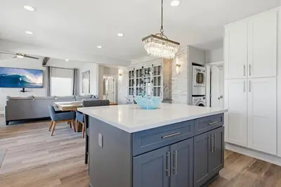 a kitchen with a blue island and a living room at Point Break 1 in San Diego