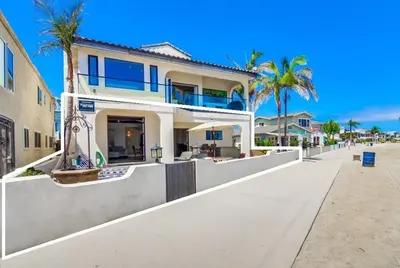 a large house on the beach with palm trees at Point Break 1 in San Diego