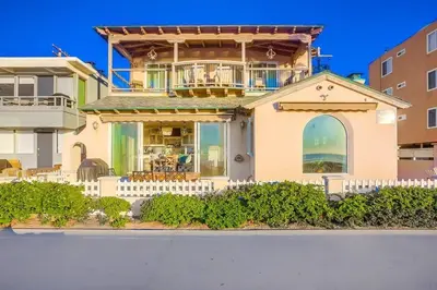 a house with a white fence in front of it at Reef Break 1 in San Diego