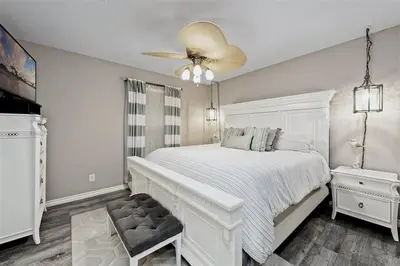 a white bedroom with a white bed and a ceiling fan at Reef Break 1 in San Diego