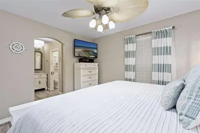 a bedroom with a white bed and a ceiling fan at Reef Break 1 in San Diego