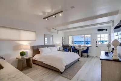 a bedroom with a bed and a desk and a table at Bayside 2 in San Diego