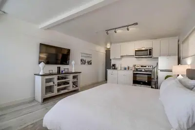 a large white room with a large bed and a kitchen at Bayside 2 in San Diego