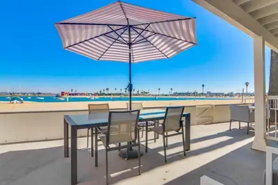 a table with chairs and an umbrella on the beach at Bayside 2 in San Diego