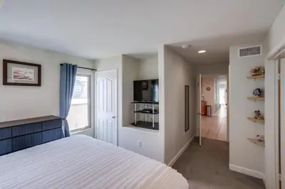 a bedroom with a white bed and a kitchen at Island Style in San Diego