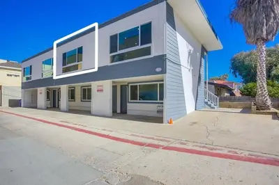 a large white building with windows on a street at Strandway Suite 6 in San Diego