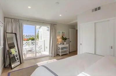 a bedroom with a large white bed and a balcony at The Shores 4 in San Diego
