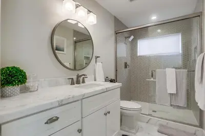 a white bathroom with a sink and a mirror at The Shores 4 in San Diego