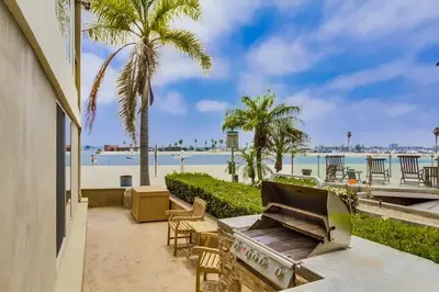 a patio with a grill and a view of the beach at Waterfront 2 in San Diego