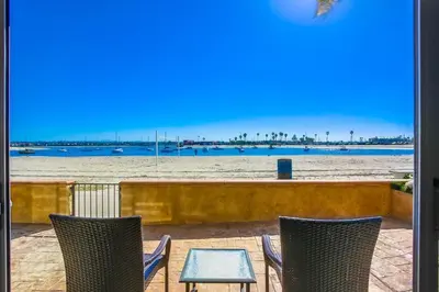 a patio with chairs and a table and the beach at Waterfront 2 in San Diego