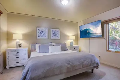 a bedroom with a bed with two night stands and two lamps at Windansea 1 in San Diego