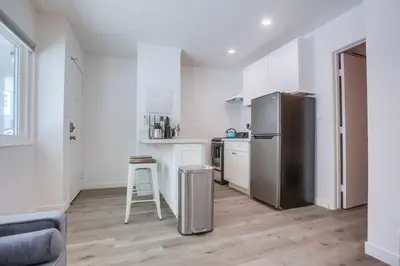 a kitchen with a stainless steel refrigerator and a stool at Strandway Suite 3 in San Diego