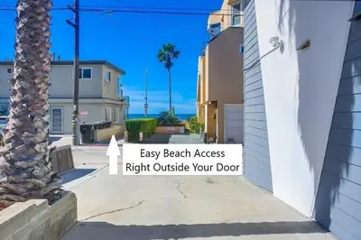 an empty street with a palm tree and a sign that reads easy beach access right at Strandway Suite 3 in San Diego