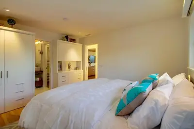 a bedroom with a large white bed with pillows at Sunset Beach in Encinitas