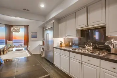 a large kitchen with a sink and a refrigerator at Surf House in Encinitas