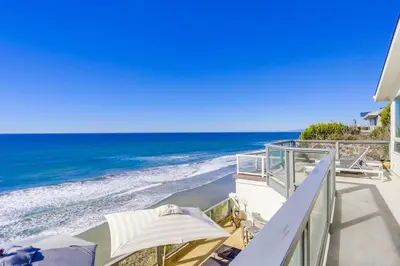 a balcony with chairs and umbrellas on the beach at Surf House in Encinitas