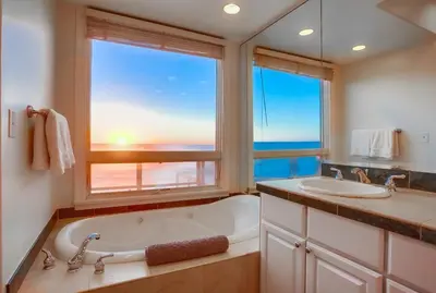 a bathroom with a tub and a sink and a window at Surf House in Encinitas