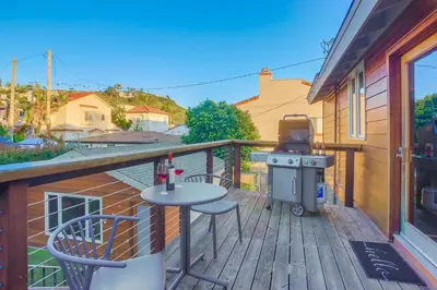 a patio with a table and a grill on a deck at Windansea 2 in San Diego