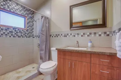 a bathroom with a toilet and a sink and a mirror at Windansea 2 in San Diego