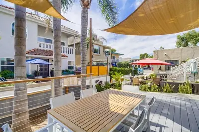 a patio with a wooden table and chairs and a building at Beach Haven 1 in San Diego