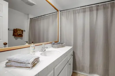 a bathroom with a sink and a shower curtain at Beach Style 2 in San Diego