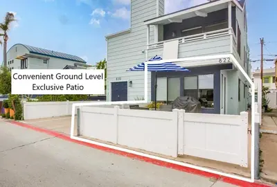 a white fence in front of a building with an umbrella at Beach Style 2 in San Diego