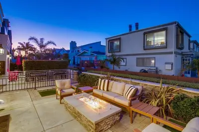 a patio with a couch and chairs in front of a house at Cali Vibes in San Diego