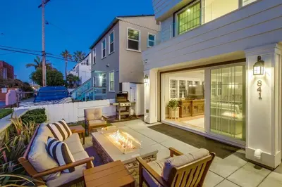 a patio with chairs and a fireplace in front of a house at Cali Vibes in San Diego