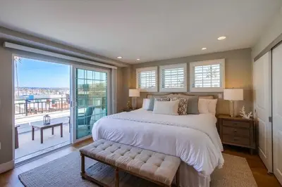 a bedroom with a large bed and a balcony at Cali Vibes in San Diego