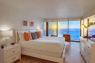 a bedroom with a bed with a view of the ocean at Capri by the Sea in San Diego