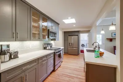 a kitchen with stainless steel appliances and wooden floors at Endless Summer 1 in San Diego