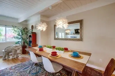 a dining room with a table with chairs and a mirror at Endless Summer 1 in San Diego